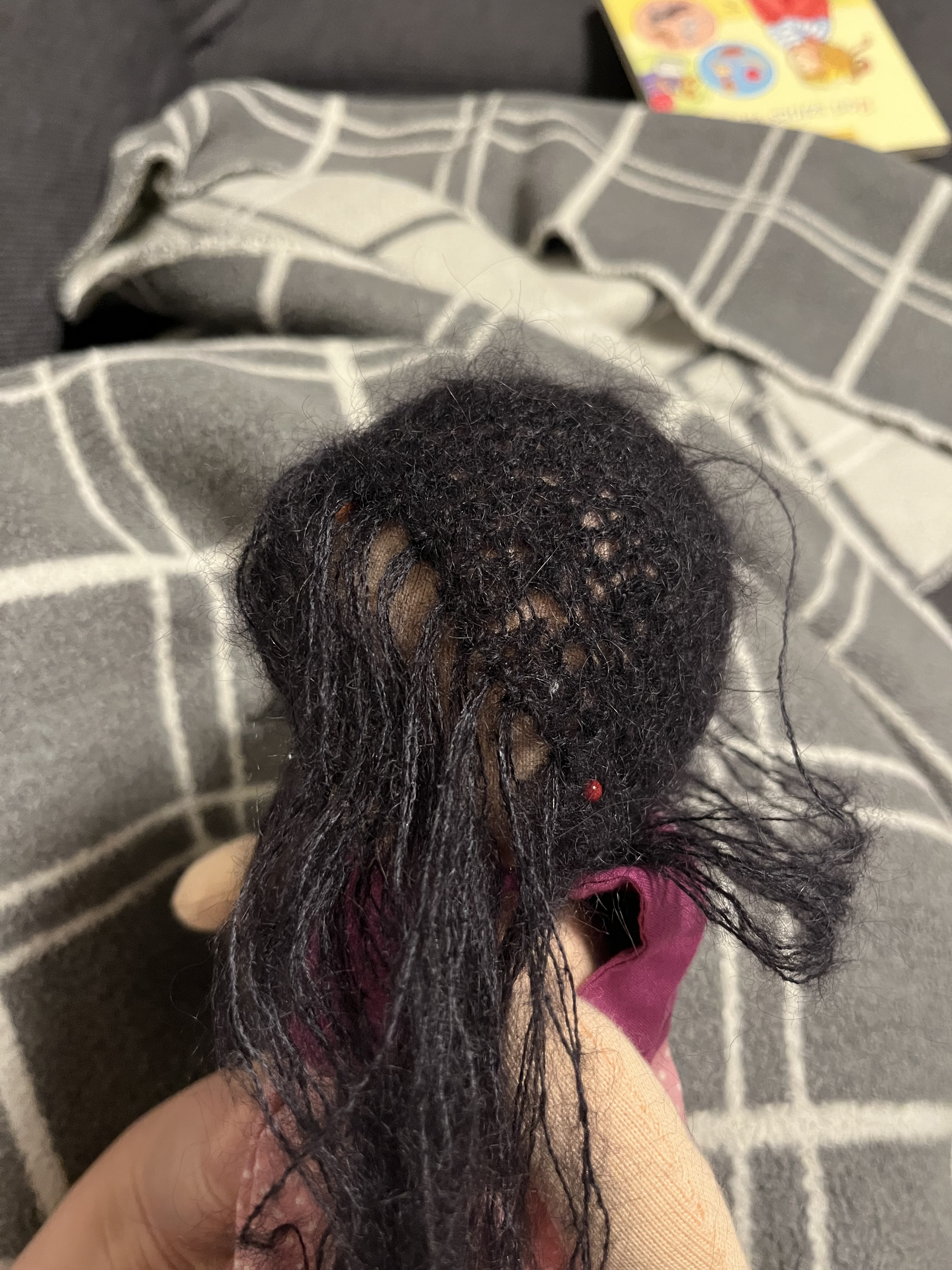 Person hand-stitching a soft doll