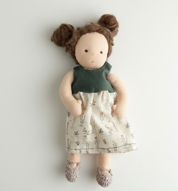 Person hand-stitching a soft doll